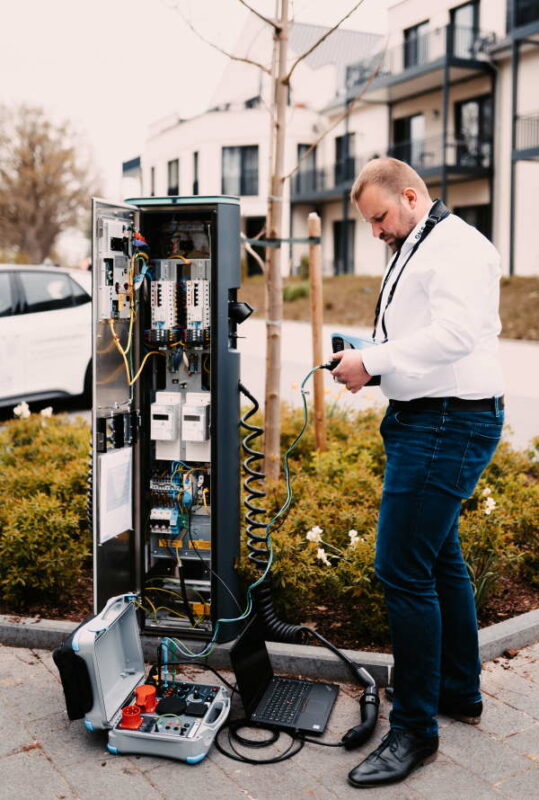 OMS E Mobility Mitarbeiter prueft Ladesaeule
